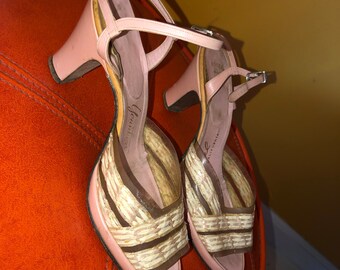 Op de afbeelding: Een paar roze plateau sandalen met een geweven ontwerp aan de voorkant. De sandalen hebben een hoge hak en een enkelband.