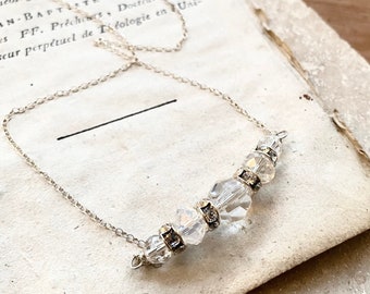 May include: A silver chain necklace with a row of clear crystal beads.