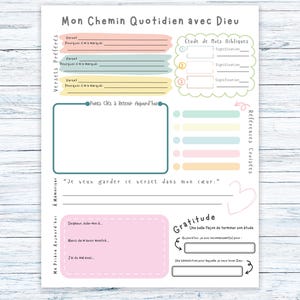Peut inclure: Une page de planificateur imprimable en français, intitulée "Mon Chemin Quotidien avec Dieu". Elle comprend des sections pour les versets, les notes et la gratitude, avec des blocs de couleurs pastel et des éléments décoratifs.