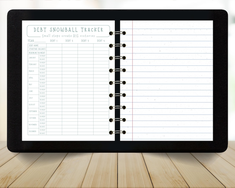 May include: A black notebook with a debt snowball tracker layout. The top of the page reads "DEBT SNOWBALL TRACKER" with the tagline "Small steps create BIG victories." The notebook has lined pages and a spiral binding.