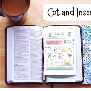 May include: An open Bible with a colorful insert titled "PSALMS The Book of Praise and Prayer." A mug of coffee sits to the left. The words "Cut and Insert" are in a white rectangle.