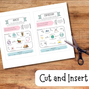May include: Two white pages with colorful illustrations and text about the books of Amos and Obadiah, with scissors on a wooden surface. The text "Cut and Insert" is on a white label below the pages.