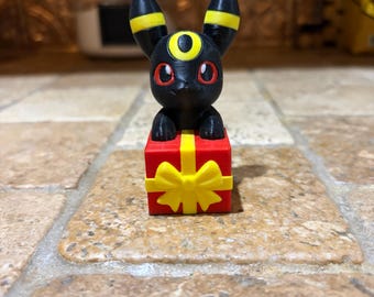 3D Printed Umbreon Figure sitting on Present | Cute Pokemon Holiday Gift | PLA Plastic Desk Pet Chibi Tabletop Decor