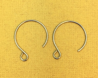 May include: Two silver hoop earrings with a simple, curved design. The earrings are made of metal and have a smooth finish.