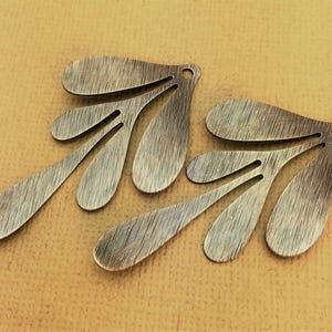 May include: Two antique gold-toned metal leaf-shaped earrings with a textured finish.
