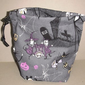 Puede incluir: Una bolsa de cord&oacute;n gris con un cord&oacute;n negro. La bolsa est&aacute; impresa con ilustraciones en blanco y negro de personajes de la pel&iacute;cula Pesadilla antes de Navidad, incluyendo a Jack Skellington, Sally y Oogie Boogie. La bolsa tambi&eacute;n tiene una l&aacute;pida con la inscripci&oacute;n "RIP".