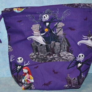 Puede incluir: Bolsa de cord&oacute;n morado con un patr&oacute;n repetido de Jack Skellington y Sally de Pesadilla Antes de Navidad. La bolsa presenta un fondo morado con ilustraciones en blanco y negro de los personajes.