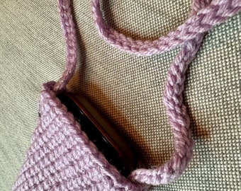 May include: A lavender crocheted bag with a long strap. The bag is small enough to fit a phone.
