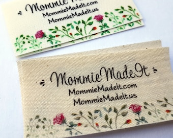 May include: A white fabric label with a floral design and the text "Mommie Made It" with the website address "MommieMadeIt.com" and "MommieMadeIt.us" printed below.