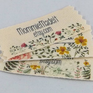 May include: Stack of beige fabric labels with a floral design and the text "MommieMadeIt etsy.com".