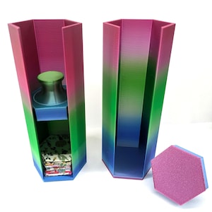 May include: Two tall hexagonal containers with a gradient finish transitioning from pink to green to blue. One container holds a stack of floral patterned hexagonal tiles and a green knob. A separate hexagonal lid with a textured pink top is placed nearby.
