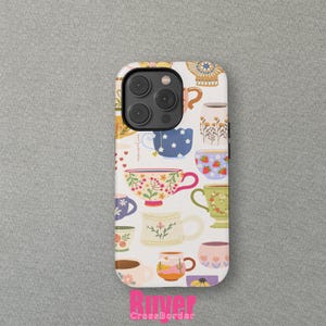 May include: A white phone case with a pattern of colourful teacups and mugs. The teacups have floral, strawberry, and other decorative designs. The case has a camera cutout and the text "River CrossBorder".