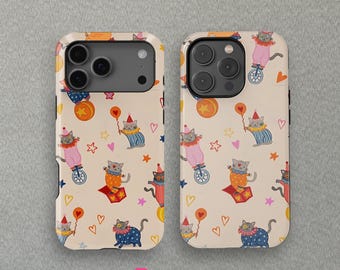 May include: Two phone cases with a repeating pattern of circus cats. The cats are dressed in colorful outfits, riding unicycles, and holding balloons. The background is a cream color with hearts and stars.