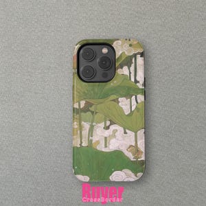 May include: A green and white phone case with a floral design and a frog. The case has a cutout for the camera lens.