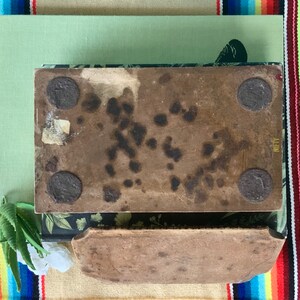 May include: Two rectangular brown ceramic tiles with a rough texture. The top tile has four black metal circles attached to the bottom. The bottom tile has the word "NIFTY" printed on the right side.