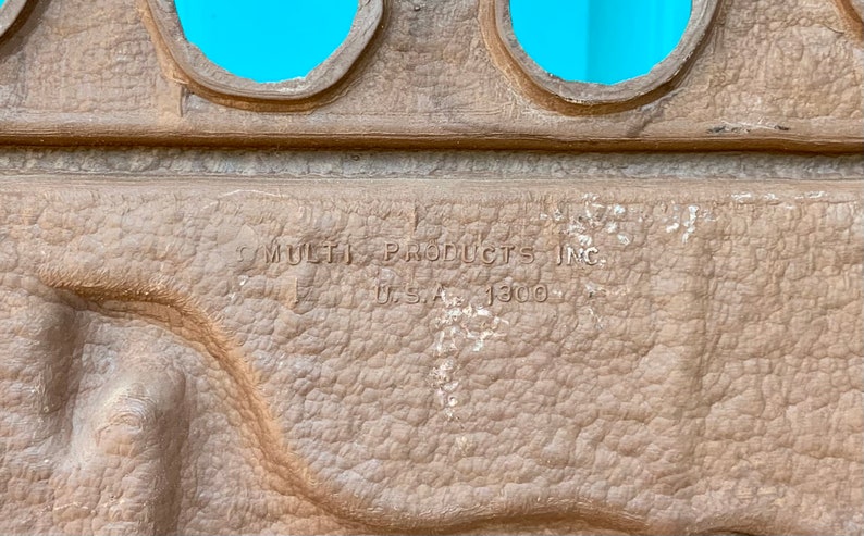 May include: Close-up of a brown textured surface with the text "MULTI PRODUCTS INC. U.S.A. 1300" embossed on it.