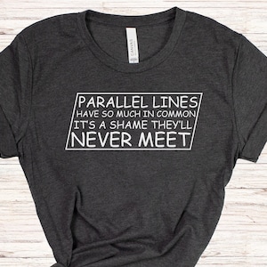 May include: A dark gray t-shirt with a white graphic that reads "PARALLEL LINES HAVE SO MUCH IN COMMON IT'S A SHAME THEY'LL NEVER MEET".
