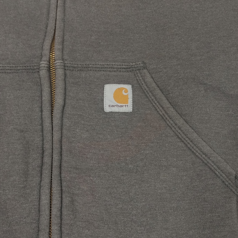 May include: A gray zip-up hoodie with a Carhartt logo patch on the left chest.