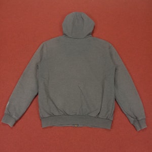 May include: A dark gray hooded sweatshirt with a zipper closure. The sweatshirt has a relaxed fit and long sleeves.