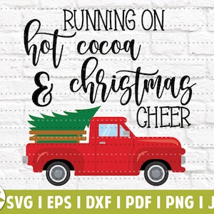 May include: Red pickup truck with a Christmas tree in the bed. The truck is on a white brick background with the text "RUNNING ON hot cocoa & christmas CHEER" above it.