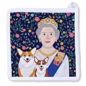 May include: Square white pot holder featuring an illustration of a woman with a crown, two corgi dogs, and a floral background. The woman wears a pearl necklace and a blue sash with medals. The background is a dark blue with colorful flowers and green leaves.