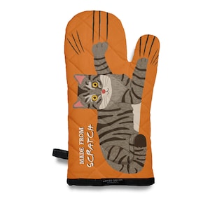 May include: An orange quilted oven mitt featuring a gray tabby cat illustration. The cat is hanging with its paws up, and the mitt has the text "MADE FROM SCRATCH". The mitt has a black trim and a loop for hanging.