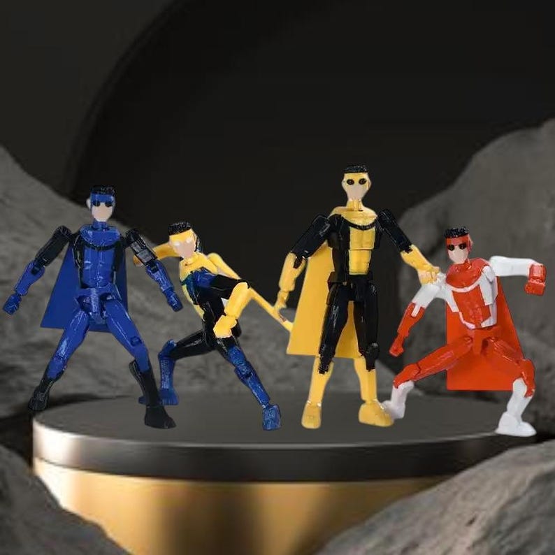 Op de afbeelding: Vier beweegbare superhelden actiefiguren in blauwe, gele, zwarte en rode kostuums met capes. De figuren poseren op een rond, donkergrijs platform tegen een donkere achtergrond.