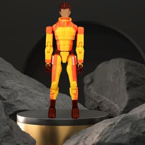 Op de afbeelding: Een geel en oranje beweegbaar actiefiguur met bruine accenten. Het figuur staat op een goud en zwart platform, tegen een donkere achtergrond met rotsformaties.