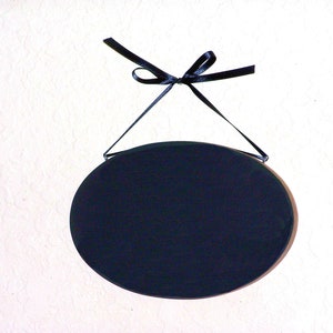 Solid wood oval shape sign with painted front, stained sides and back. 16 color choices. Measures approx. 8 inches by 5.5 inches. Black or white text saying

Your choice one or two words

Includes elegant scroll and choice hanger style.