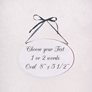 Solid wood oval shape sign with painted front, stained sides and back. 16 color choices. Measures approx. 8 inches by 5.5 inches. Black or white text saying

Your choice any one or two words

Includes elegant scroll and choice hanger style.