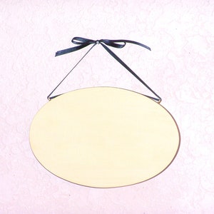 Solid wood oval shape sign with painted front, stained sides and back. 16 color choices. Measures approx. 8 inches by 5.5 inches. Black or white text saying

Your choice one or two words

Includes elegant scroll and choice hanger style.