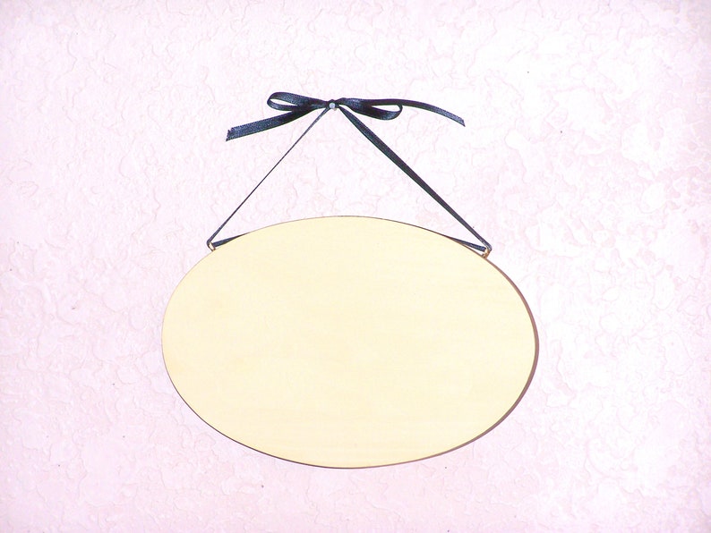 Solid wood oval shape sign with painted front, stained sides and back. 16 color choices. Measures approx. 8 inches by 5.5 inches. Black or white text saying

Your choice one or two words

Includes elegant scroll and choice hanger style.