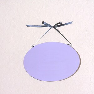 Solid wood oval shape sign with painted front, stained sides and back. 16 color choices. Measures approx. 8 inches by 5.5 inches. Black or white text saying

Your choice one or two words

Includes elegant scroll and choice hanger style.