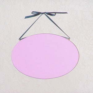Solid wood oval shape sign with painted front, stained sides and back. 16 color choices. Measures approx. 8 inches by 5.5 inches. Black or white text saying

Your choice any one or two words

Includes elegant scroll and choice hanger style.