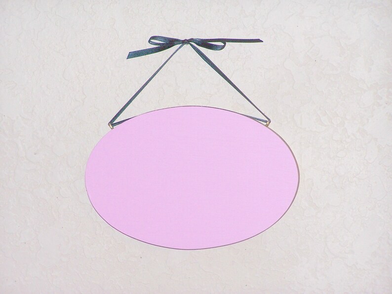 Solid wood oval shape sign with painted front, stained sides and back. 16 color choices. Measures approx. 8 inches by 5.5 inches. Black or white text saying

Your choice any one or two words

Includes elegant scroll and choice hanger style.