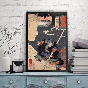 May include: A vintage Japanese woodblock print depicting a samurai warrior wielding a spear, with a large Buddha figure in the background. The print features vibrant colors and intricate details, including a mountain range and clouds.