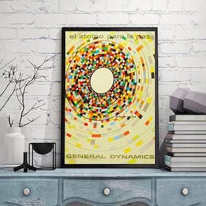 May include: A framed poster featuring a colourful circular design made up of squares and rectangles. The poster has the text "el atomo para la paz" at the top and "GENERAL DYNAMICS" at the bottom. The text "Solar Dynamics" is in the lower right corner of the poster.