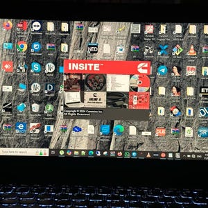 Może przedstawiać: Ekran laptopa wyświetlający pulpit z wieloma ikonami i dużym oknem otwartym na program INSITE™. Program ten jest przeznaczony do silników Cummins i zawiera tekst "Copyright © 2004 Cummins Inc. All Rights Reserved."