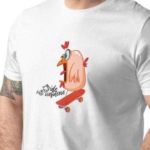 Op de afbeelding: Wit T-shirt met een cartoonkip die een bril draagt en skateboard. De tekst "Stride with confidence" is op het T-shirt gedrukt.