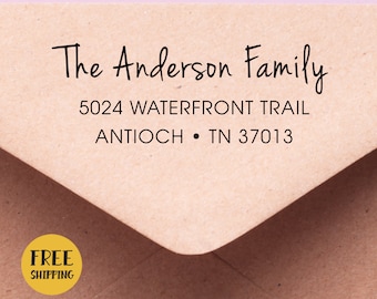 May include: A brown envelope with the text "The Anderson Family" in a handwritten style. Below the family name is the address: 5024 WATERFRONT TRAIL, ANTIOCH • TN 37013. A yellow circle with the words "FREE SHIPPING" is in the lower left corner.