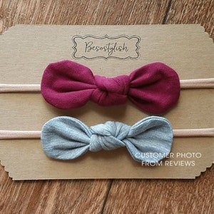 Peut inclure: Deux bandeaux pour cheveux en tissu nou&eacute;, un bordeaux et un gris, pr&eacute;sent&eacute;s sur une carte marron. La carte porte les mentions "Besostylish" et "CUSTOMER PHOTO FROM REVIEWS". Les bandeaux sont fix&eacute;s &agrave; un &eacute;lastique fin de couleur neutre.