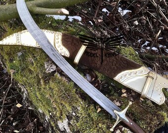 May include: A curved, silver-colored sword with a brown leather scabbard decorated with gold accents and studs. The scabbard has the text "MODEL KNIVES" on it.