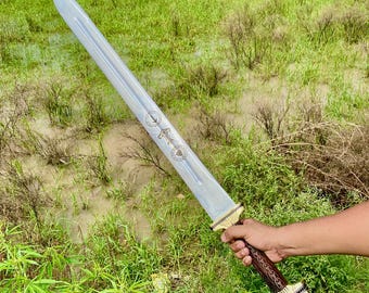May include: A silver sword with a brown wooden handle and gold accents. The sword has a decorative design on the blade and a leather strap on the handle.