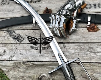 May include: A silver-colored sword with a black handle and a silver-colored metal hand guard. The sword is lying on a wooden surface with a silver-colored metal gauntlet with spikes.