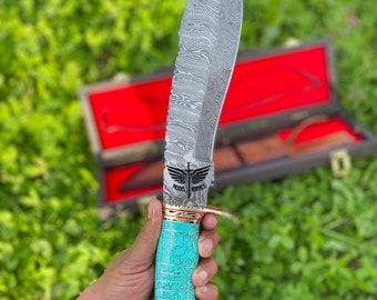 May include: A turquoise and gold-accented knife with a Damascus steel blade. The knife has a decorative handle and the words "Model Knives" are engraved on the blade.
