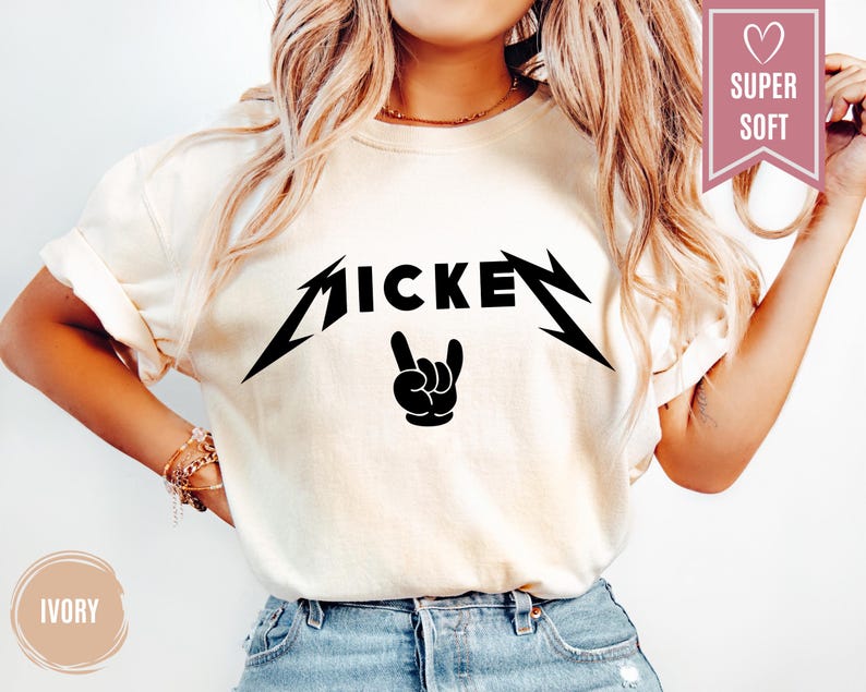 Pu&ograve; includere: T-shirt color avorio con una grafica nera che recita "MICKEY" in un font stilizzato, con un gesto della mano rock and roll. La maglietta ha maniche corte ed &egrave; realizzata in un materiale morbido.