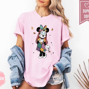 Puede incluir: Camiseta rosa claro con un gr&aacute;fico de Minnie Mouse con un disfraz de patchwork. El dise&ntilde;o incluye un lazo colorido, hojas de oto&ntilde;o y el texto "Blossom" en un c&iacute;rculo rosa. La camiseta tiene una etiqueta "Super Soft".