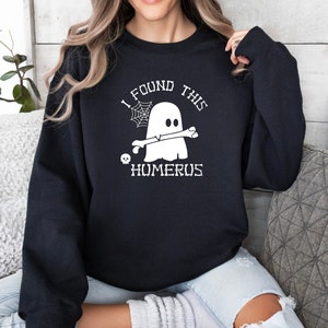 May include: Black sweatshirt with a white graphic of a ghost holding a bone with the text "I found this humerus".