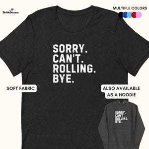 May include: Dark gray t-shirt with the text "SORRY. CAN'T. ROLLING. BYE." in white. The shirt is made of soft fabric and is also available as a hoodie. Multiple color options are shown.