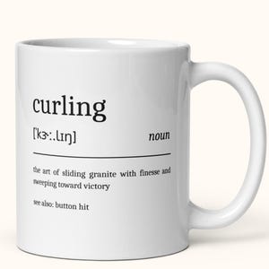 Op de afbeelding: Witte keramische mok met het woord "curling" in het zwart, samen met de fonetische uitspraak en definitie. De definitie beschrijft de sport curling, inclusief de term "button hit".